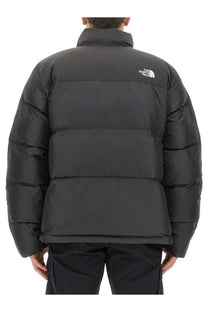 The back side of a black the north face men’s saikuru puffer jacket with horizontal stitching and a white logo