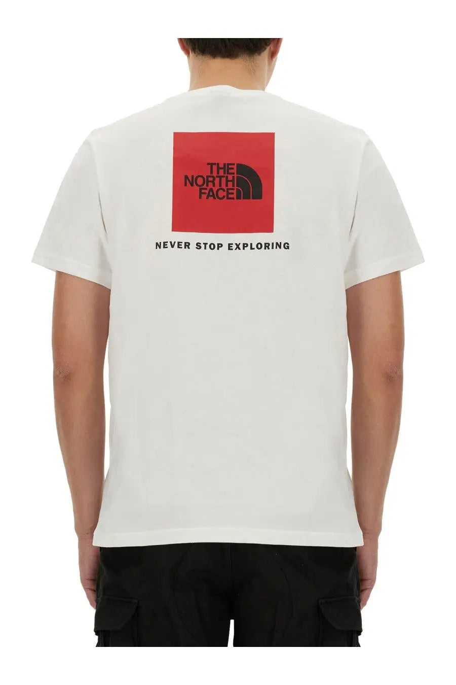 The north face men’s white short-sleeved t-shirt features a bold red square logo with black text and never stop exploring phrase