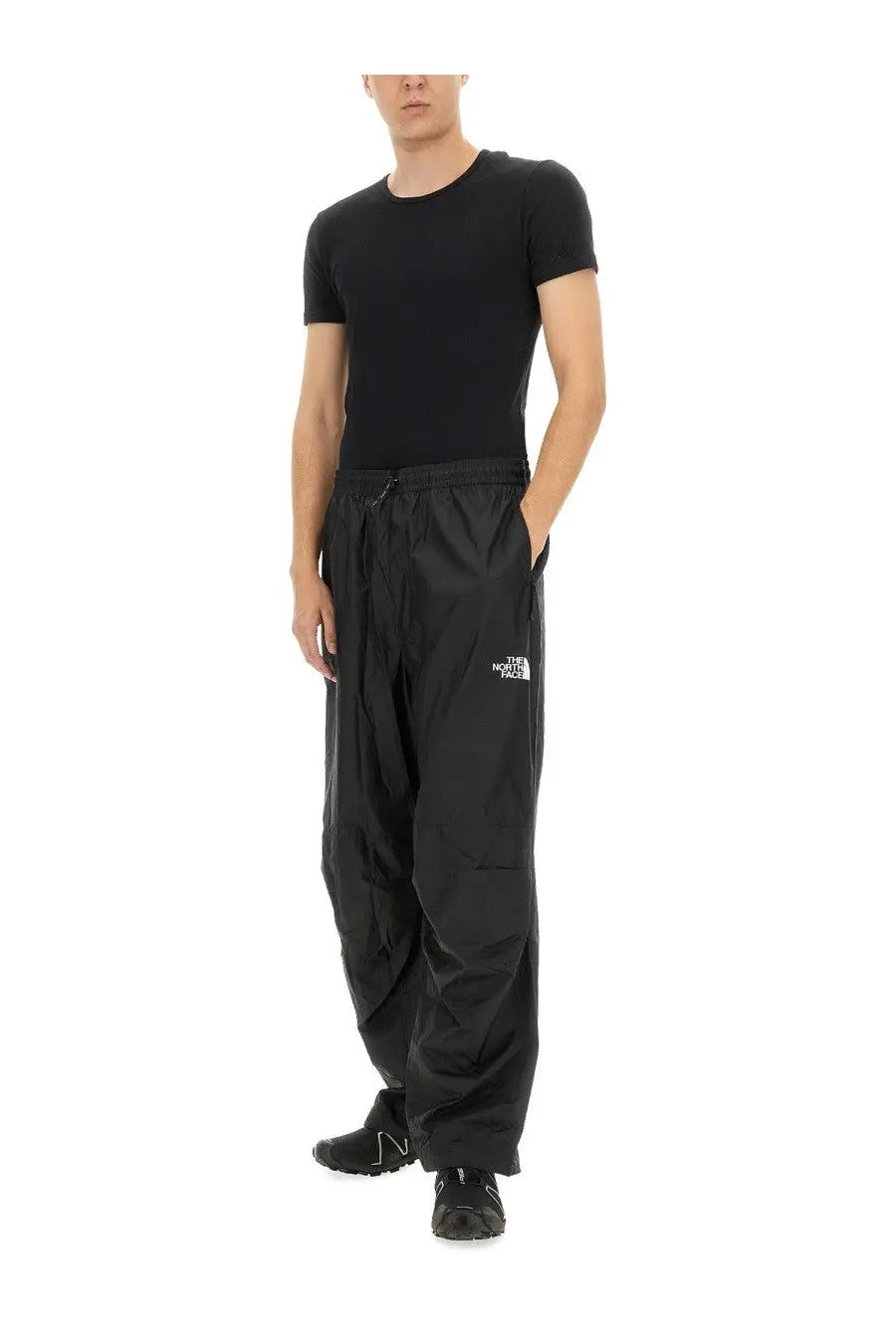 Black the north face men’s wind track cargo pants with drawstring waist and white logo on thigh in nse black color