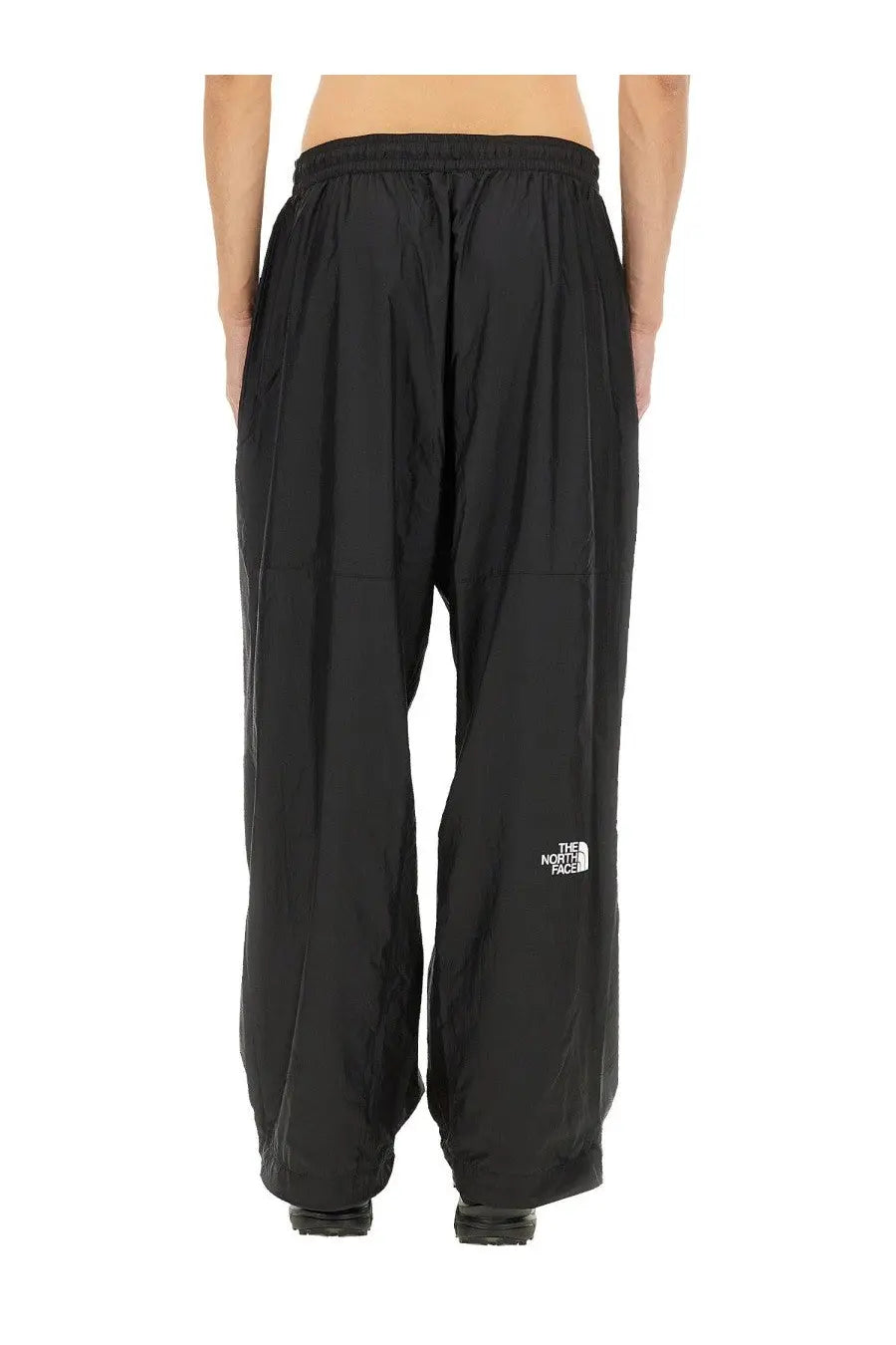 Black the north face men’s wind track pants with a white logo on the lower leg designed for wind resistance
