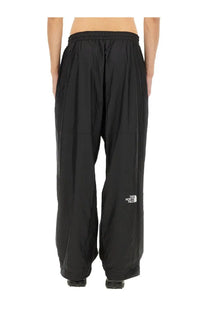 Black the north face men’s wind track pants with a white logo on the lower leg designed for wind resistance