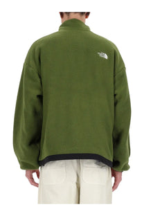The back of an olive green fleece jacket with black trim and a white the north face logo on the back