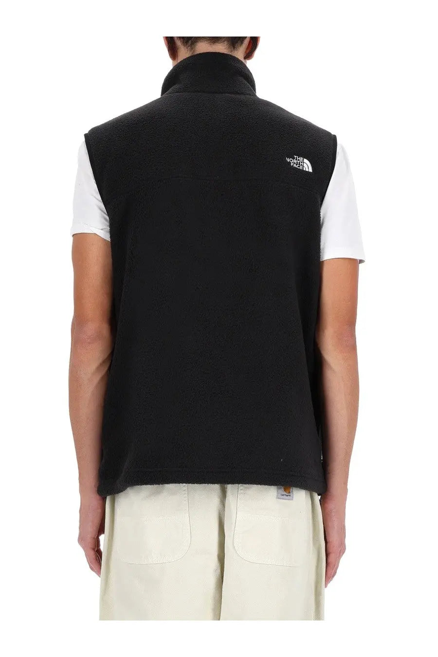 The back side of a black fleece vest with a high collar and the north face logo on the upper back for men