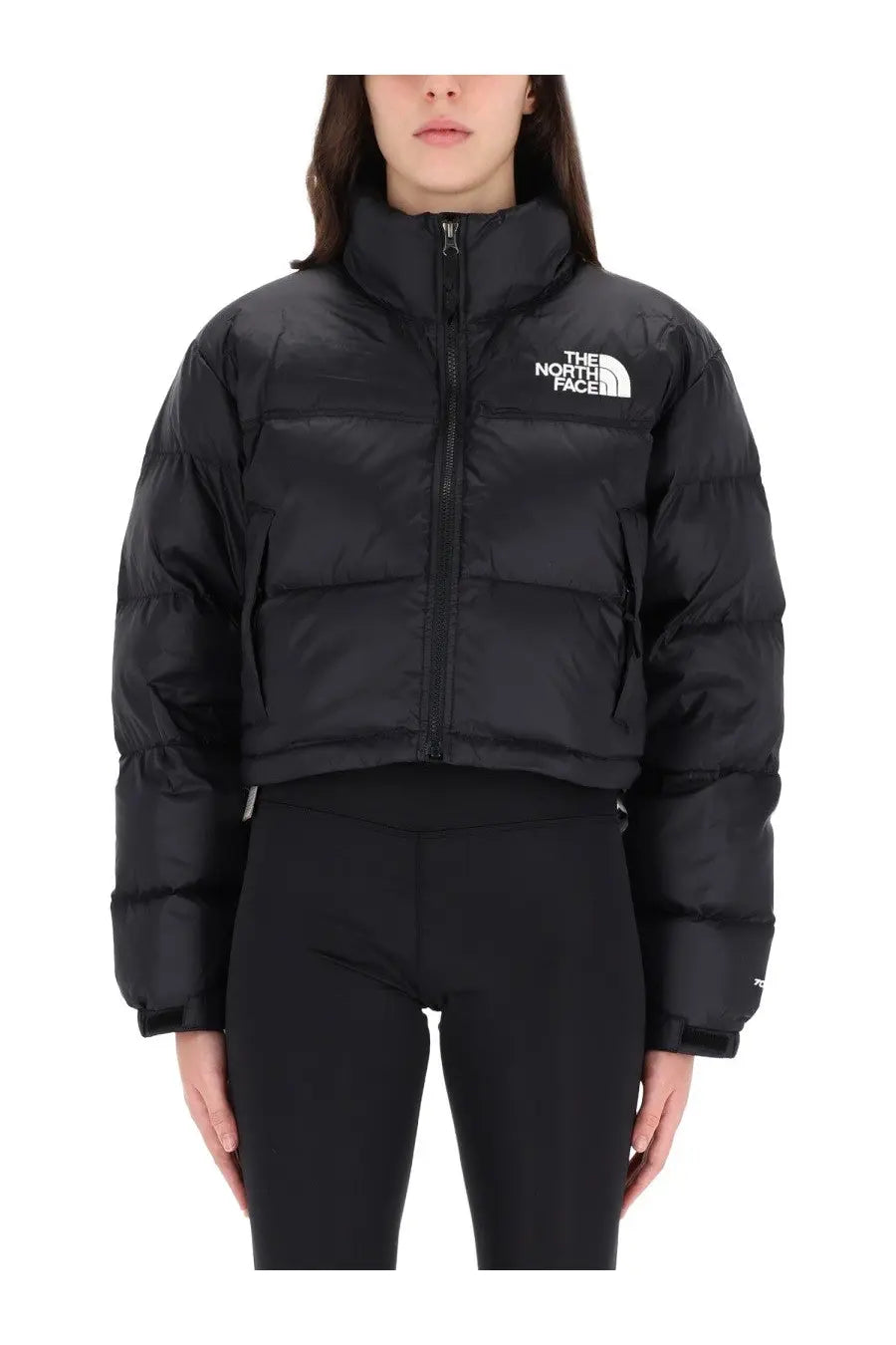 The North Face women’s black Nuptse jacket is a puffer with a high collar front zipper and logo on the chest