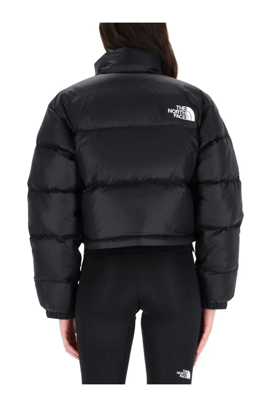 The back of The North Face women’s black Nuptse jacket featuring a quilted puffer design with a white logo