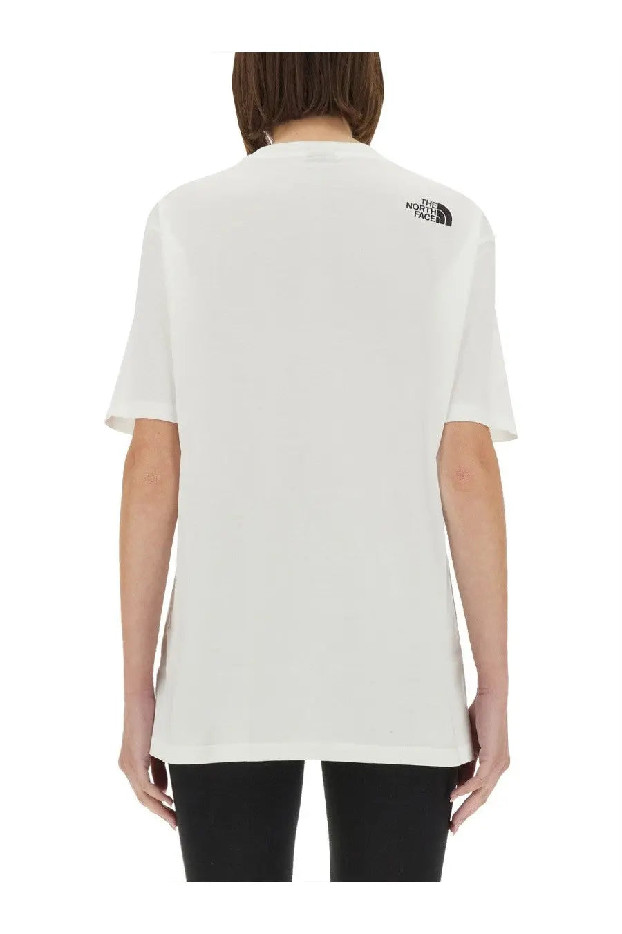 The back side of the north face women’s simple dome oversized shirt white features a black logo on a cotton fabric