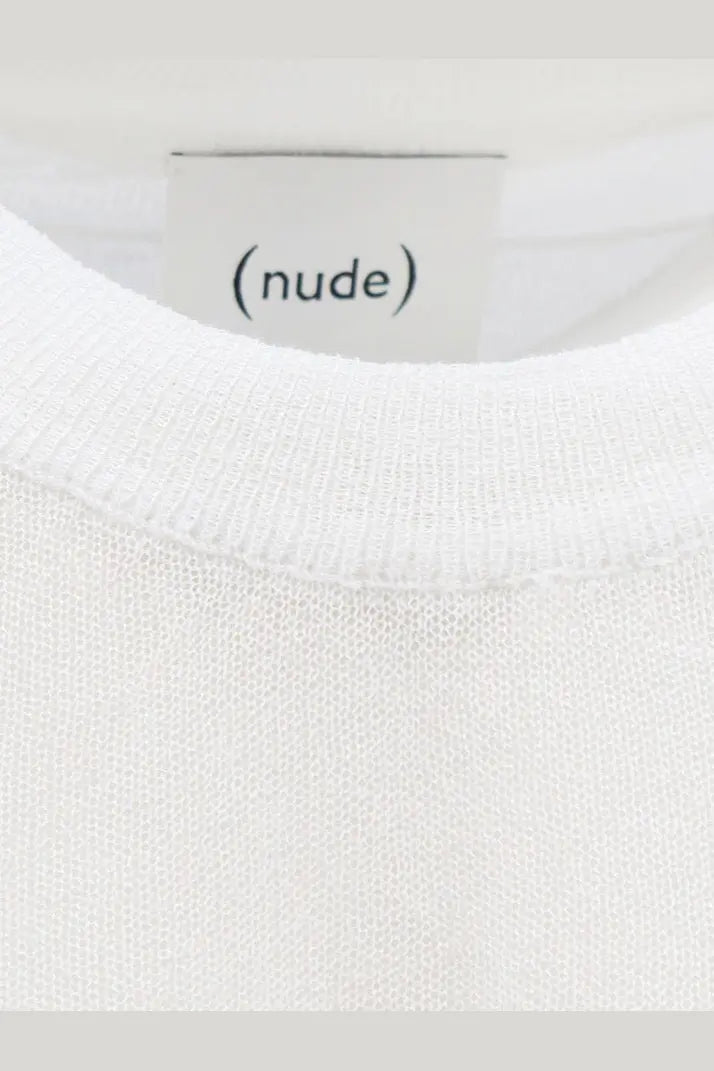 A minimalist white cotton blend crewneck shirt with soft textured knit fabric and a clean nude label