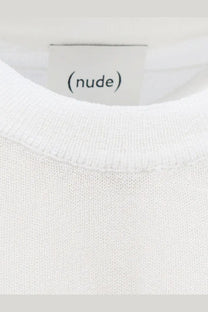 A minimalist white cotton blend crewneck shirt with soft textured knit fabric and a clean nude label