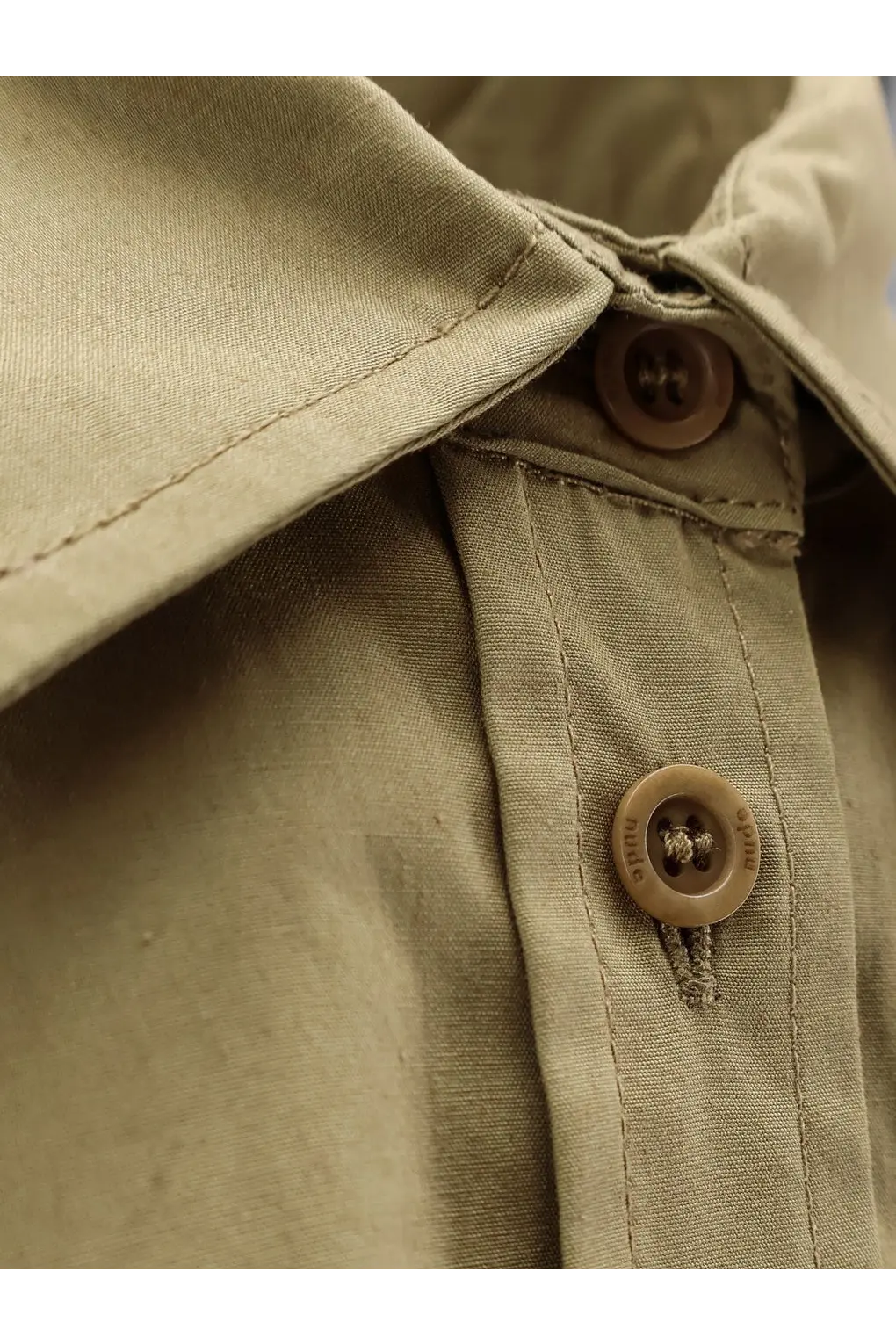 Beige button engraved with mille on the collar of a nude womens green cotton shirt made of khaki fabric