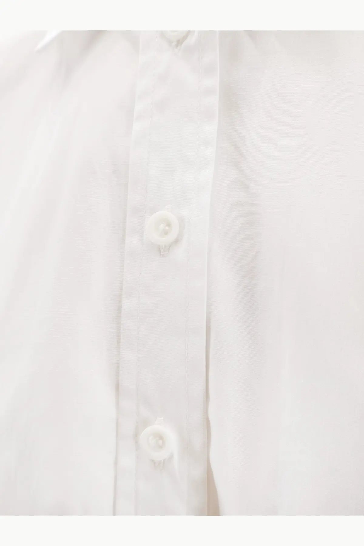 Nude women’s white cotton shirt with crisp fabric and matching white buttons along the front placket