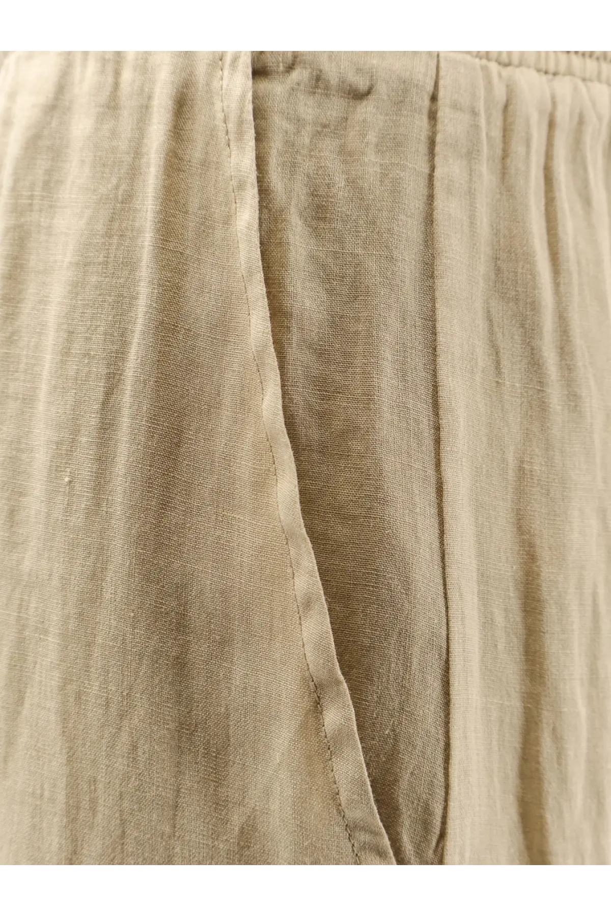 Beige women’s linen blend trousers with relaxed texture and visible seam detailing in a nude green style