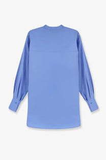 Nude women’s oversize cotton shirt in light blue with long sleeves and a subtle seam across the chest