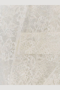 Nude women’s sleeveless lace jacket in white featuring delicate ivory lace fabric with intricate floral patterns and sheer texture