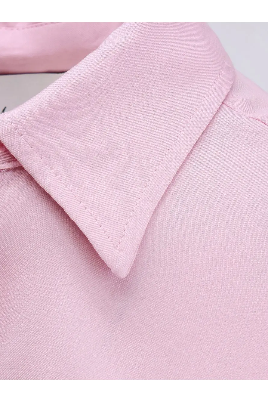 A soft pink neatly stitched collar of a women’s viscose dress shirt made from smooth woven fabric