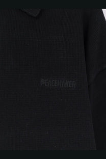 Black knitted cotton Oamc peacemaker men’s polo shirt with subtle peacewaker embroidery on the chest