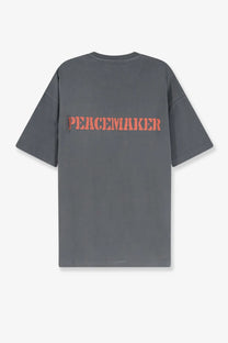 Back view of oamc peacemaker men’s dark gray oversized cotton t-shirt with bold orange peacemaker lettering