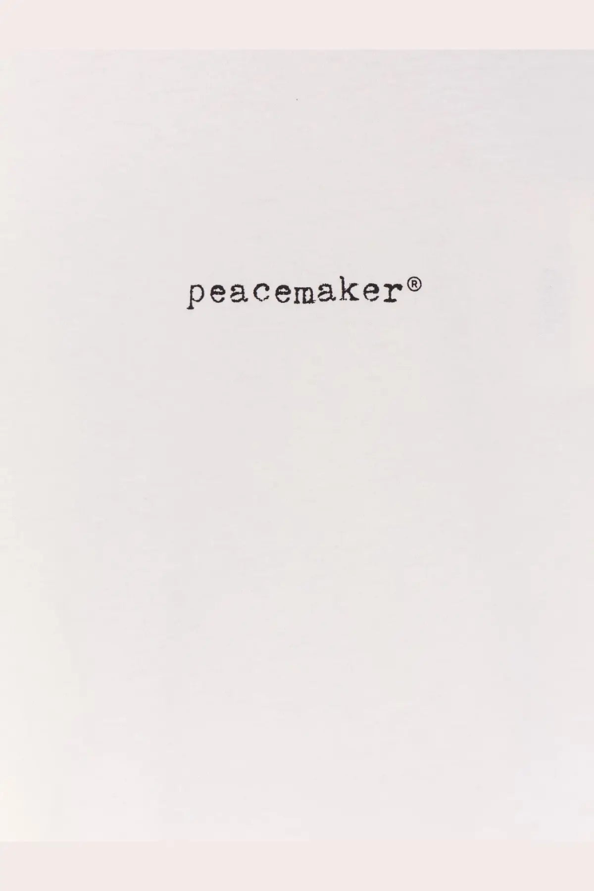 Black peacemaker logo text on the white oamc peacemaker men’s cotton shirt front design
