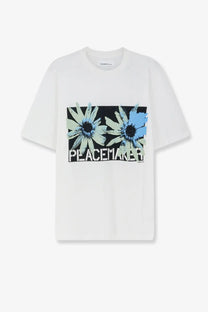 White cotton oamc peacemaker men’s t-shirt with bold blue and green daisies graphic and block letters print