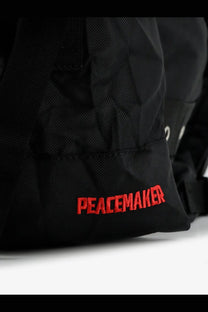Black nylon Oamc Peacemaker men’s jungle backpack with bold red embroidered peacemaker branding