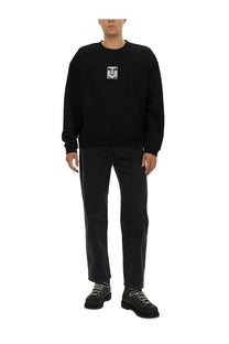 Obey men’s black cotton crewneck sweatshirt with a small white graphic patch on the chest