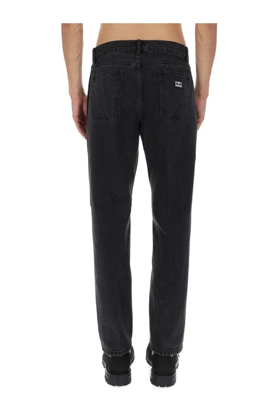 Back side of obey men’s hardwork black denim jeans with straight-leg cut and small white logo patch on pocket