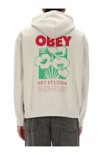 Obey men’s beige cream-colored hoodie with bold red and green floral graphic and art studios text on front