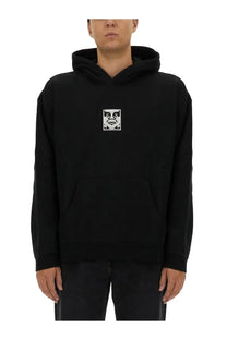 Obey men’s black hoodie with white eye and mouth graphic on chest in comfortable sweatshirt material