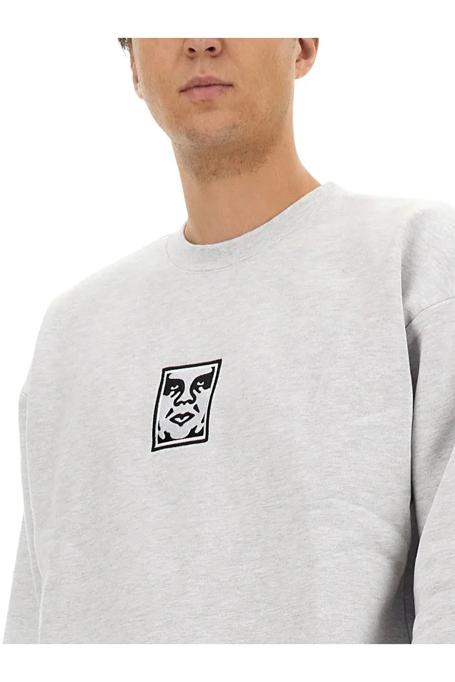 Obey men’s gray heathered sweatshirt with black and white embroidered face logo on the chest front