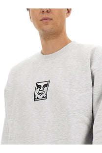 Obey men’s gray heathered sweatshirt with black and white embroidered face logo on the chest front