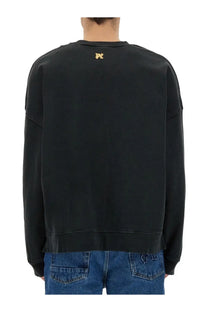 Black oversized cotton Palm Angels men’s sweatshirt back view with small gold embroidered burning monogram logo