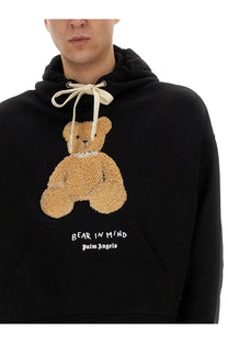 Palm Angels men’s black hoodie with tan textured teddy bear appliqué and pearl-like collar featuring bear in mind text