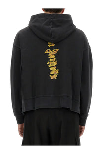 Back view of palm angels men’s black hoodie with vertical gold flame graphic on cotton fabric