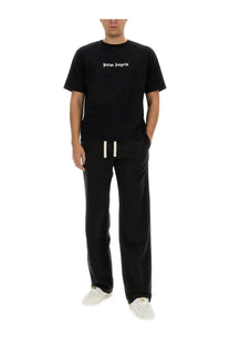 Black palm angels t-shirt with white embroidered logo across the chest paired with men’s black pants
