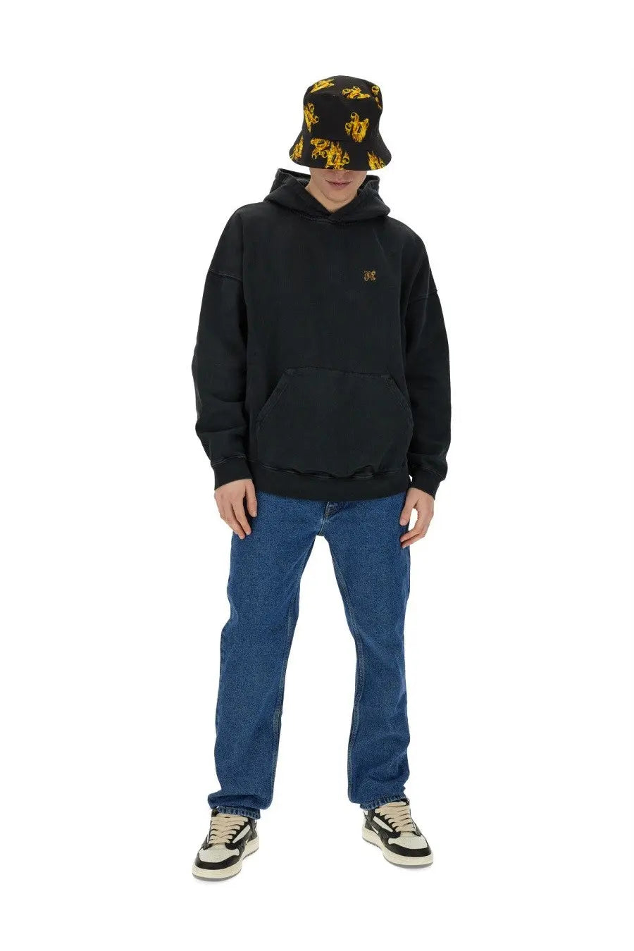 Black oversized hoodie with small gold embroidered logo on chest paired with palm angels men’s straight leg blue jeans