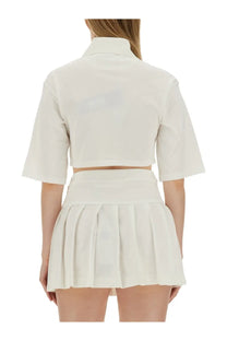 White cropped short-sleeved polo shirt with collar and matching pleated skirt from palm angels women’s monogram collection