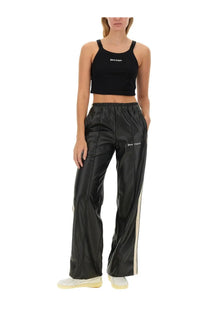 Black faux leather track pants with white side stripes and palm angels branding on the waistband for women