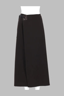 Black wrap skirt from paloma wool with sleek minimalist design and subtle metallic button detail at the waist