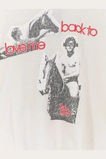 Off-white cotton t-shirt with distressed black and red graphic print of man riding horse and back to love me text