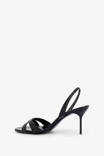 Black patent leather slingback sandal with slender heel and minimalist crisscross straps from Paris Texas women’s Lidia collection