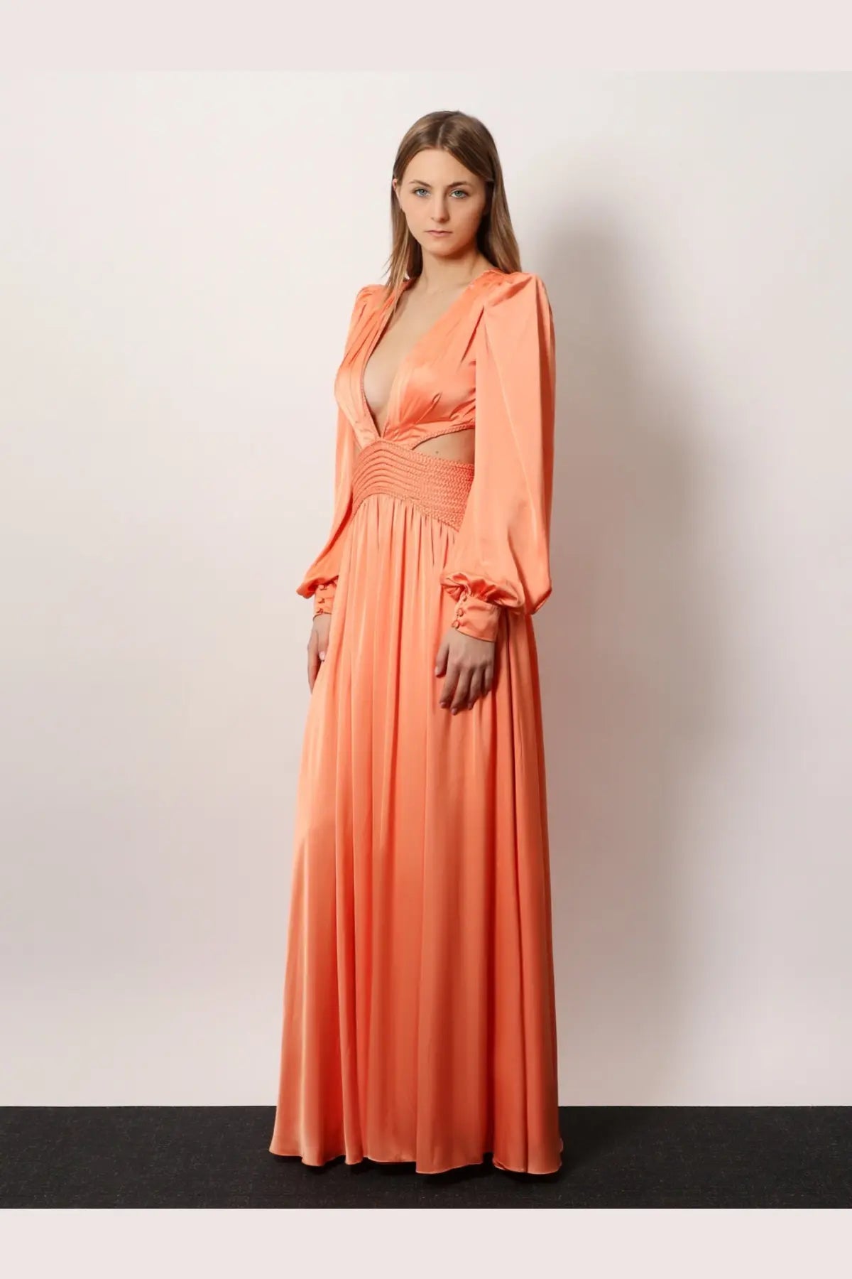 Patbo women’s satin sunset long dress is a flowing peach-colored satin gown with long sleeves and a deep v-neckline