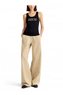 Black patou tank top with white lettering paired with beige women’s pants for casual wear