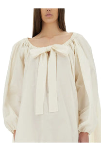 Cream-colored blouse with puffed sleeves and gathered square neckline with central bow from patou women’s ruffle hem dress white