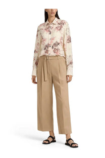 A woman wears a Paul Smith women’s printed long-sleeved blouse with a soft pink and muted purple floral pattern on off-white