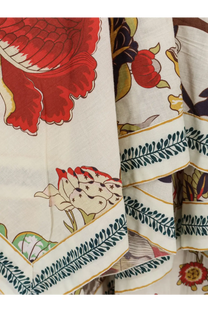 A cream-colored fabric scarf with vibrant red green and gold floral pattern paired with philippa 1970 women’s cova multicolor cotton dress white