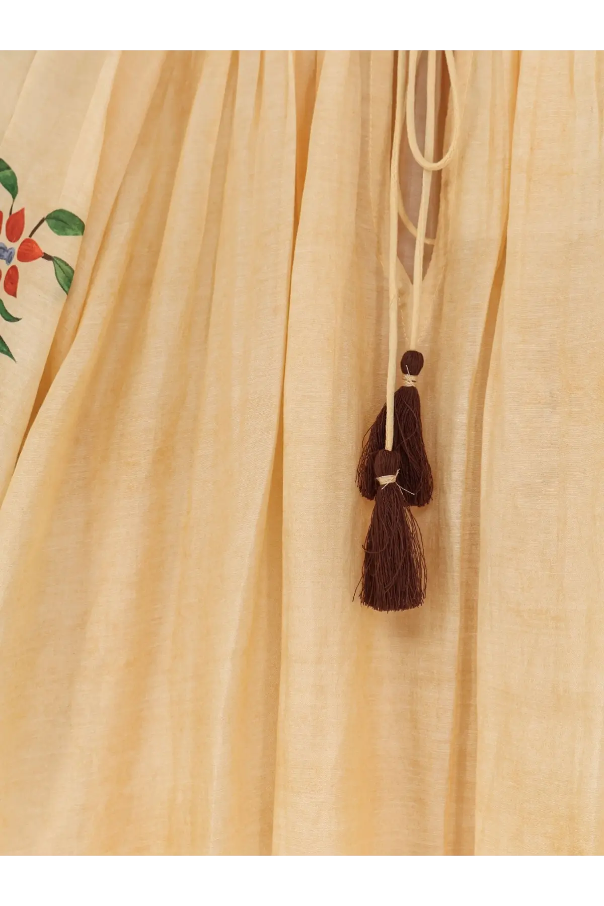 Beige linen dress with embroidered red and green floral detail and a brown tassel from philippa 1970 palmira modal shirt yellow