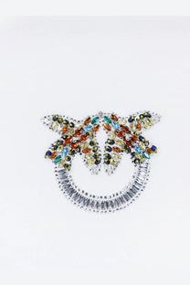 Pinko women’s white cotton shirt with a sparkling silver pinocchio brooch adorned with multicolored gemstones