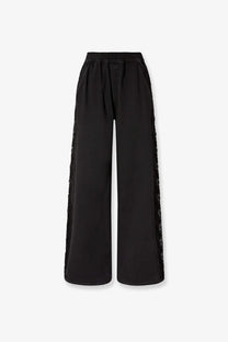 Pinko women’s black denim wide-leg trousers with sheer lace trim along the outer seams