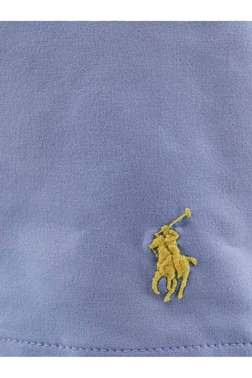 A yellow embroidered polo player logo on a light blue cotton shirt paired with polo ralph lauren men’s blue nylon swim trunks