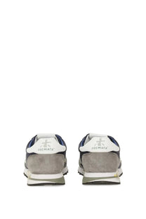 Back view of premiata men’s sneaker lucy blue in navy and gray suede with white rubber soles and premiata logo on heel