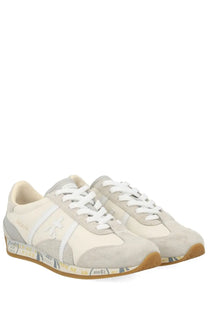Premiata women’s sneaker jackyx 25d in beige and gray suede with white laces and a gum rubber sole with printed text